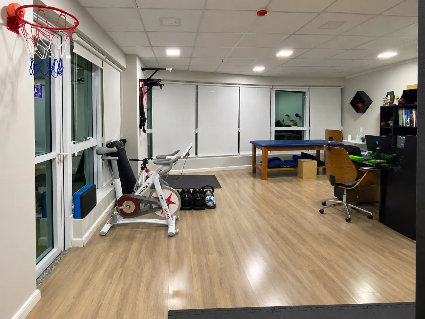 Espaço integrado de fisioterapia e treino da Boese, com bicicleta ergométrica e cesta de basquete